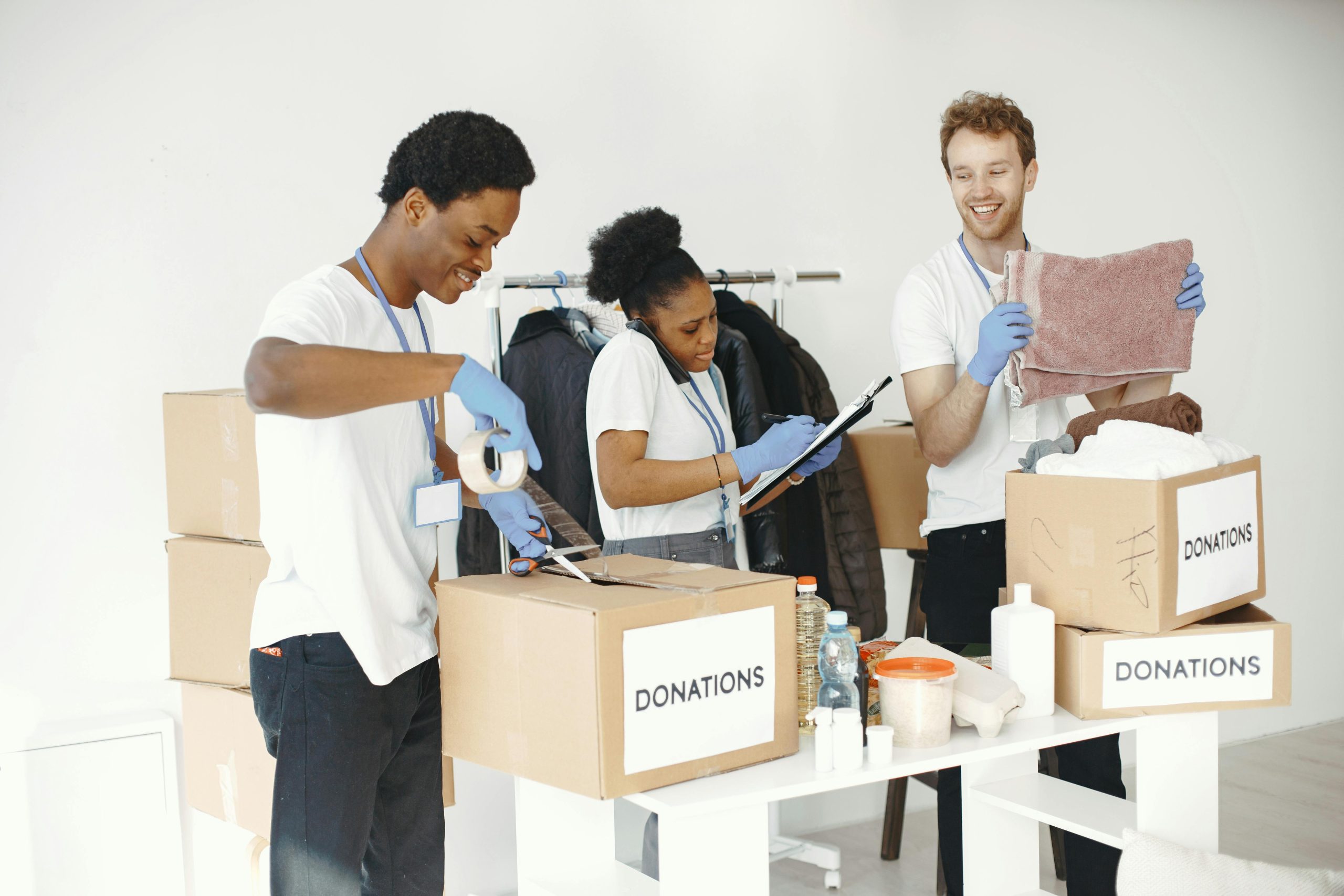 Form 1023 vs. Form 1023-EZ: Which One Does Your Nonprofit Need? Diverse volunteers happily sorting donation boxes indoors during a charity event.