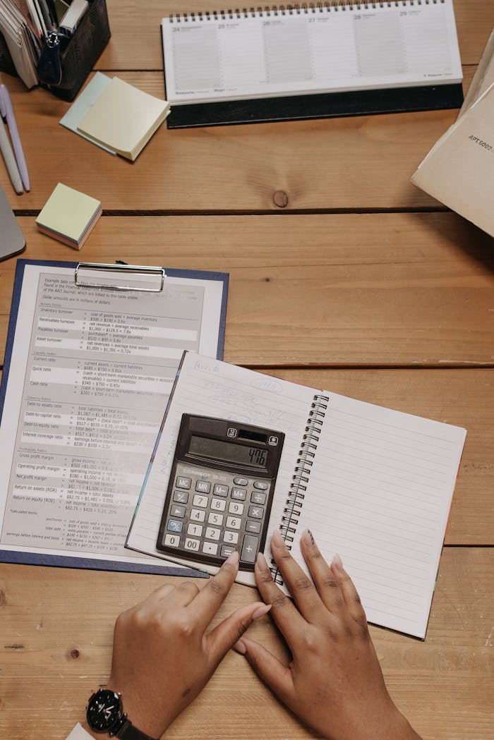 How to Form a Nonprofit Corporation in Texas: The State-Level Steps Top view of hands using calculator on office desk surrounded by documents and sticky notes.